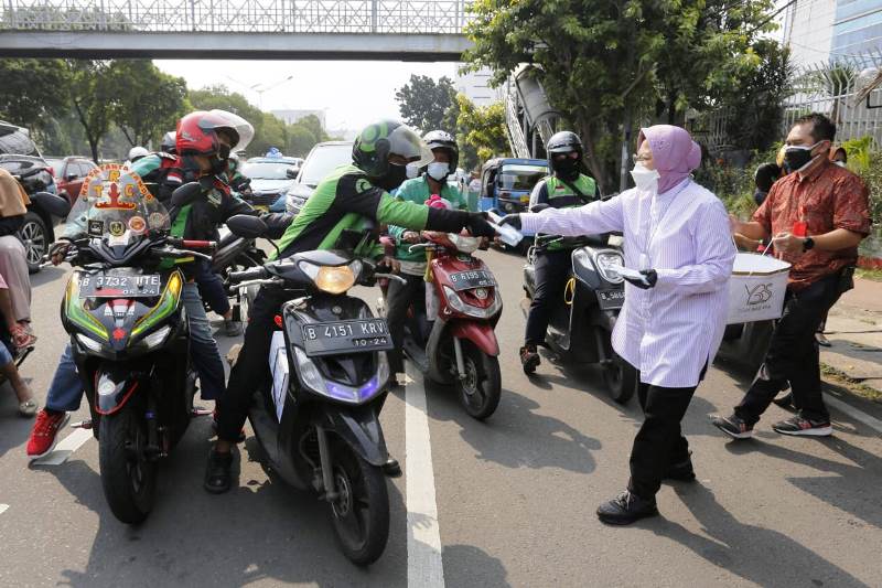 Indonesian Minister of Social Affairs Tri Rismaharini hands out face masks.